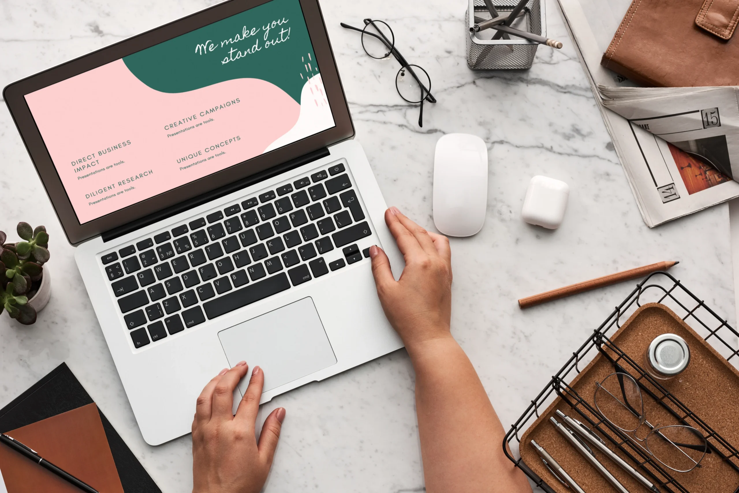 Person using a laptop with stylish pink and green cards nearby.