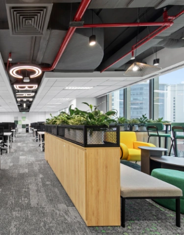 Modern office lounge with comfortable seating and greenery.