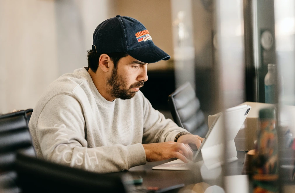 Man focused on working with a laptop indoors.