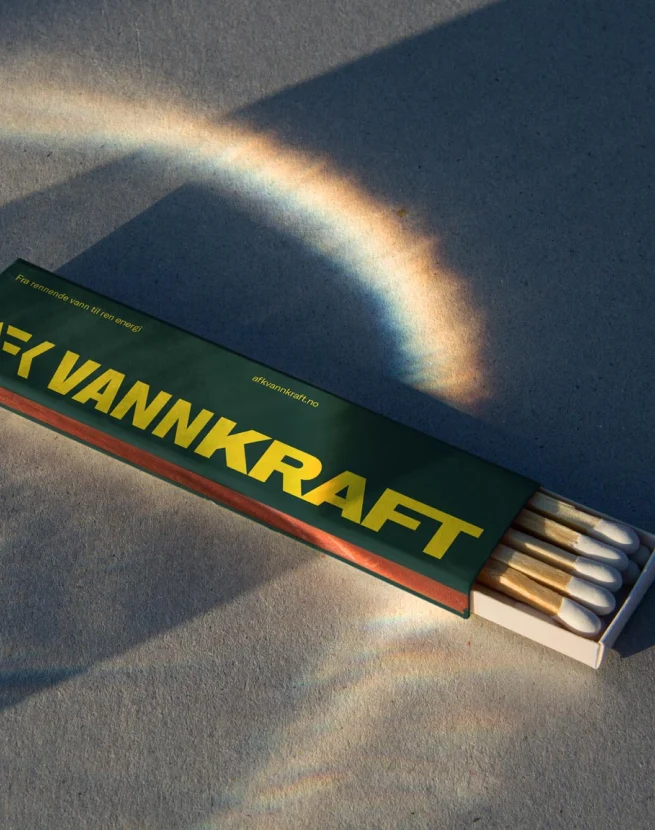 A colorful circular rainbow above a box of matches labeled 'VANNKRAFT'.