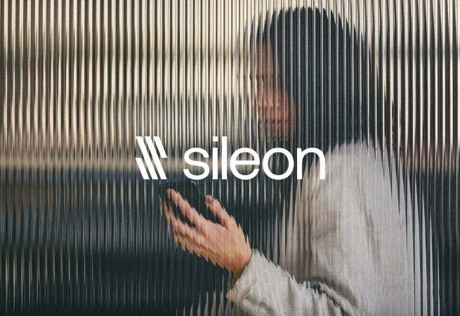 A person holding a smartphone with the Sileon logo overlay.