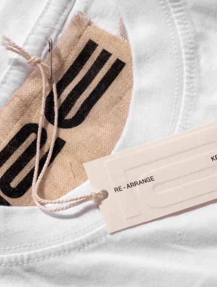 Close-up of a white garment with a beige tag labeled 'DR. ROMANCE'.