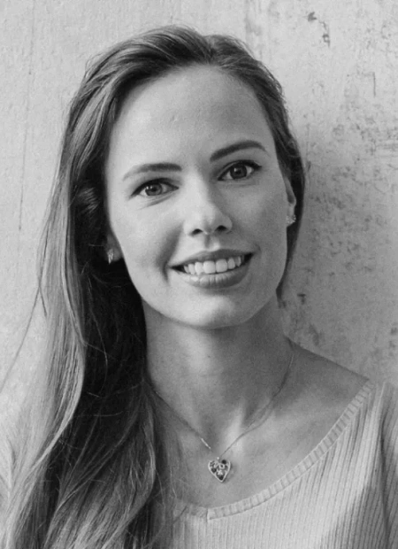 Black and white portrait of a smiling woman with long hair.