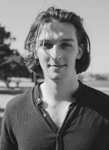 Black and white portrait of a young man outdoors.