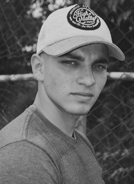 Young man wearing a cap and a serious expression.