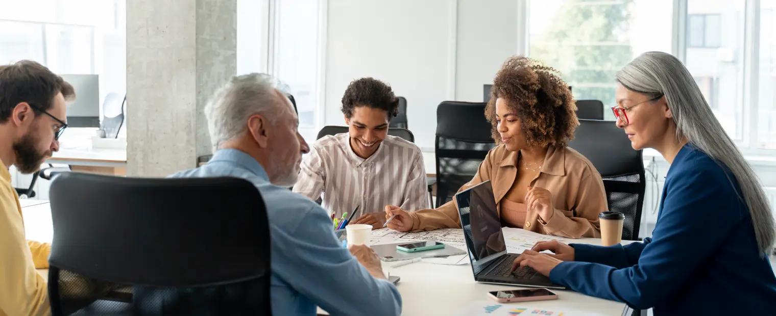 Three professionals collaborate over documents in a bright office.