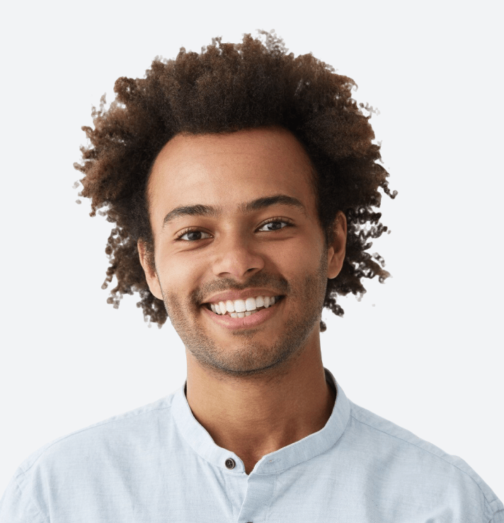 Smiling young man with curly hair in white shirt.