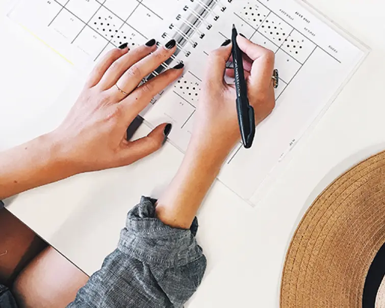 Person drawing architectural plans with ruler and pen.