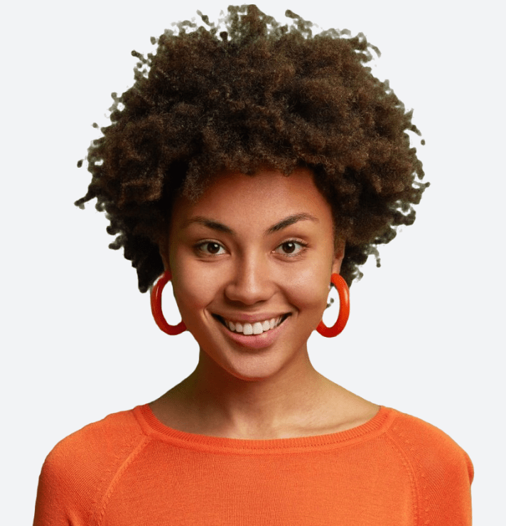 Smiling woman with curly hair wearing orange and red hoop earrings.